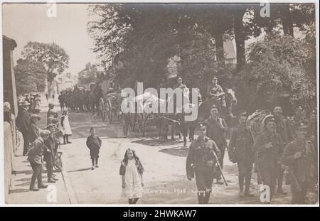 Royal Engineers in Southwell, Nottinghamshire, 1915: Foto einer Kolonne von Soldaten, die in voller Uniform mit Gewehren durch die Straße marschieren, sowie mehrere Pferdewagen mit Fahrern. Einheimische Männer, Frauen und Kinder können gesehen werden, wie sie das Ereignis beobachten und ein Mädchen und ein Junge scheinen mit den Soldaten zu marschieren Stockfoto