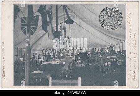 Central Young Men's Christian Association (YMCA) Volunteer Tent während des Ersten Weltkriegs. Das Zelt ist mit Fahnen geschmückt und Soldaten sitzen innen um Tische herum. Die Postkarte wurde aus dem Lager Newhaven geschickt Stockfoto