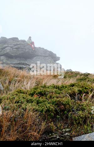 Der Tourist liegt auf einem Felsen in der Nähe des Berges Petros, helle Kleidung für Touristen. Stockfoto