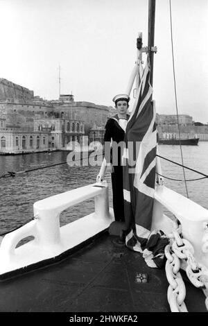 Vorbereitung auf die britische Abreise aus Malta. Der 18-jährige Radiobetreiber Brian Houston, der aus Ilford, Essex, kommt und den Union Jack bei Sonnenuntergang in H.M.S. zeigt Blake. Im Hintergrund befindet sich das Marinehauptquartier Valletta, Malta. 1972 72.-00107-006. Januar Stockfoto