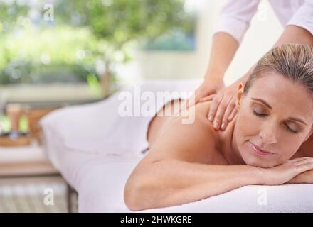 Die magischen Hände einer Masseuse. Eine kurze Aufnahme einer Frau in einem Day Spa, die sich auf einem Massagetisch entspannt. Stockfoto