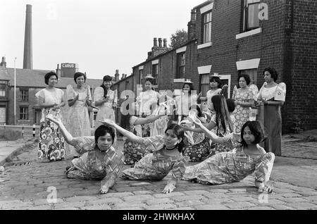 Frauen aus Manila, die in einer Mühle in Rochdale, Lancashire, arbeiten, zeigen in den Kopfsteinpflasterstraßen von Rochdale nationale Tänze. 20.. Juli 1972. Stockfoto