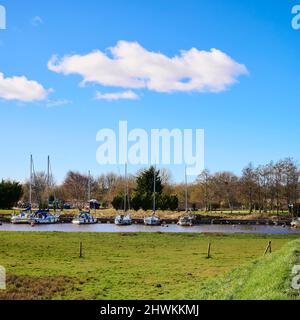 Weiße Wolken ziehen über festgetäuten Segelbooten Stockfoto