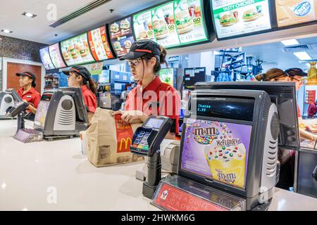 Sydney Australien, Circular Quay McDonald's, Restaurant Fast-Food-Theke asiatische Frau, Arbeitsuniform Mitarbeiter m&m's Stockfoto