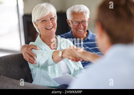 Ich schüttle das nicht Überdrehte Aufnahme eines Treffens eines Finanzberaters mit einem älteren Paar zu Hause. Stockfoto