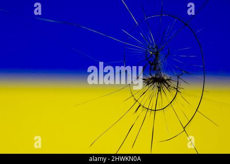 Zerrissenes Glas auf dem Hintergrund der ukrainischen Flagge Stockfoto