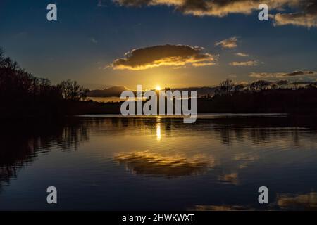 Sonnenuntergang hinter der Ely Cathedral, vom Roswell Pits Nature Reserve aus gesehen Stockfoto