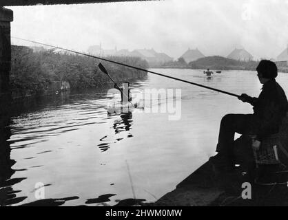 Leeds und Liverpool Canal, Sonntag, 23.. Juli 1972. Unser Bild zeigt ... auf dem Leeds Liverpool Canal treffen sich zwei verschiedene Sportarten von Angesicht zu Angesicht, energische Kanufahrer der Lancashire, der Tscheshire und der Isle of man TAVR Association gleiten an sitzenden Sonntagsanglern vorbei. Die Kanufahrer auf dem Bild treten bei den individuellen Kanu-Zeitfahren des TAVR an, der einstehende Fischer ist ein Junge, der begierig ist, eine Leine zu nassen. TAVR Territorial and Army Volunteer Reserve Stockfoto