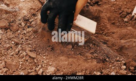 Archäologische Ausgrabungen am Tatort, menschliche Überreste im Boden. Kriegsverbrecherszene. Der Ort der Massenerschießung der Menschen. Menschliche Überreste - Knochen Stockfoto