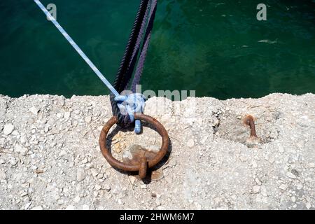 Blaue Seile, die an einem Festmacherring befestigt sind Stockfoto