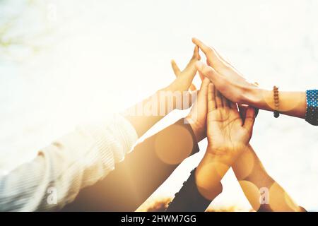 Yay US. Zugeschnittene Aufnahme einer nicht erkennbaren Gruppe von College-Freunden mit hohen Drehungen, während sie draußen standen. Stockfoto