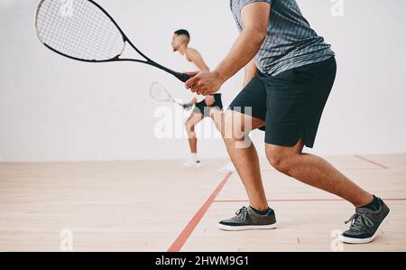 Du musst leicht auf deinen Füßen bleiben. Aufnahme von zwei jungen Männern, die ein Squash-Spiel spielen. Stockfoto