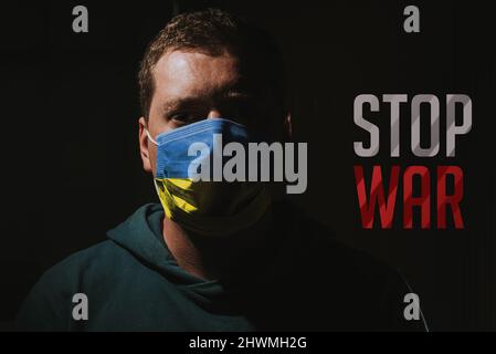 Mann mit Ukraine-Flaggen-Maske mit Text STOP war Stockfoto