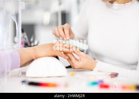 Frau Hände, mit denen die Maniküre Master Feilen Nägel Stockfoto