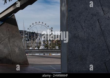 Riesenrad und Kolumbus-Denkmal am Port Vell in Barcelona, Spanien. Stockfoto