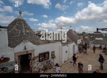 Alberobello, Apulien, Italien. August 2021. Tolle Aussicht auf das charmante historische Dorf. Die Menschen strömen in die engen Gassen, um diese charmante Stadt zu besuchen. Stockfoto