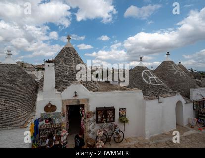 Alberobello, Apulien, Italien. August 2021. Tolle Aussicht auf das charmante historische Dorf. Die Menschen strömen in die engen Gassen, um diese charmante Stadt zu besuchen. Stockfoto