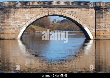 Die Kirche St. Edward the Confessor in Brotherton wurde durch die alte Brücke über den Fluss Aire bei Ferrybridge gesehen Stockfoto