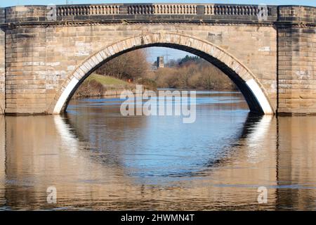 Die Kirche St. Edward the Confessor in Brotherton wurde durch die alte Brücke über den Fluss Aire bei Ferrybridge gesehen Stockfoto