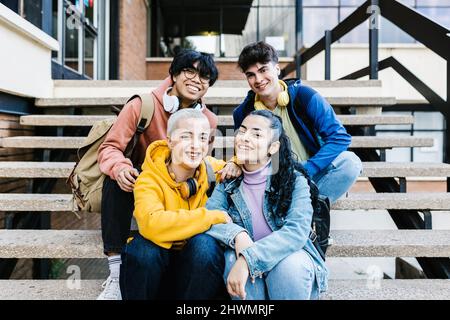 Millennial Gruppe von jungen Studenten Freunde sitzen auf dem College-Campus Stockfoto