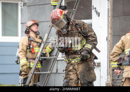 Die Feuerwehrleute arbeiten daran, einen Strukturbrand zu löschen Stockfoto