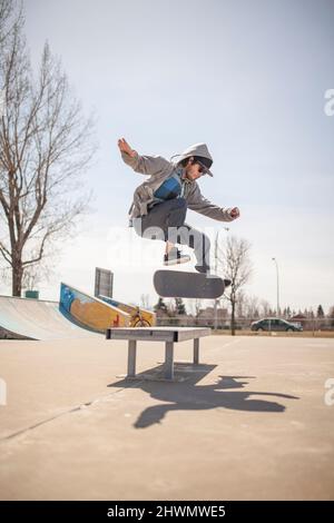 Junger Skateboard-Enthusiast, der einen Kickflip macht Stockfoto