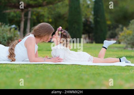 Die Tochter küsst sich im Park draußen auf die Nase ihrer Mutter Stockfoto