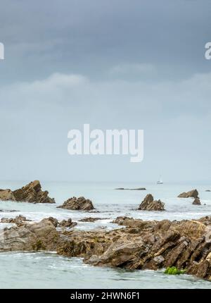 Vorbeifahrende Boote fahren in Richtung Felsen, was Gefahr auf See andeutet, in der Nähe der Lizard Peninsular, Dollar Cove, benannt nach den Silberdollar, die hier von einem Anc gefunden wurden Stockfoto