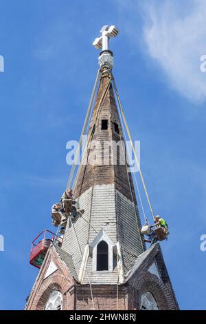 Arbeiter reparieren den Kirchturm von Saint John’s Church in Burlington, Iowa mehrere Wochen nach schweren Stürmen und Derecho, die die Staaten des Mittleren Westens getroffen haben. Stockfoto
