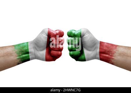 Zwei Hände schlagen sich gegenseitig auf weißem Hintergrund zu. Länderflaggen bemalten Fäuste, Konfliktkrisenkonzept zwischen italien und italien Stockfoto