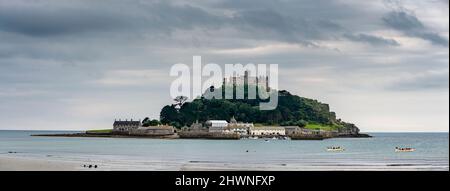 Breites Panoramabild, stürmischer Himmel, aber ruhige Sommermeere, sanft beleuchtet von diffuser Sonne und zwei Teams in großen Holzbooten, die über die Szene rudern. Stockfoto