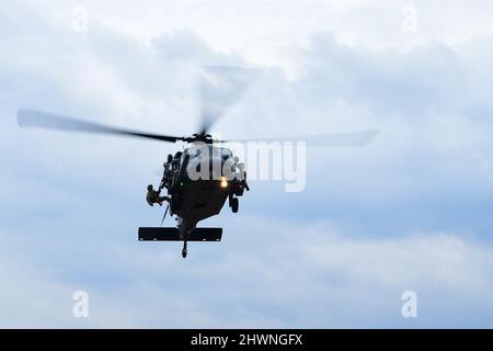 Ein dem Rettungsgeschwader 57. zugeordneter Pararescueman führt ein dynamisches Hubtraining mit einem HH-60G Pave Hawk in Rumänien durch, 4. März 2022. Die 56. RQS und die 57. RQS, die beide dem 31. Fighter Wing, Aviano Air Base, Italien, zugeordnet sind, bieten Such- und Rettungskapazitäten für das NATO-Bündnis und führen gleichzeitig gemeinsame Trainingsmissionen mit der rumänischen Luftwaffe durch. Beide sind in der Lage, bei Tag und Nacht Allwettermissionen in Operationssälen weltweit durchzuführen Luftwaffe Foto von Senior Airman Noah Sudolcan) Stockfoto