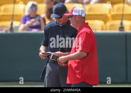 Baton Rouge, LA, USA. 6. März 2022. Louisiana Tech Head Coach Josh Taylor trifft sich mit Brian Crochet, einem Schiedsrichter, um während der NCAA Softball Action zwischen den Louisiana Tech Bulldogs und den LSU Tigers im Tiger Park in Baton Rouge, LA, einen Lineup-Wechsel zu machen. Jonathan Mailhes/CSM/Alamy Live News Stockfoto