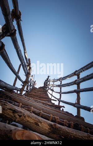 Traditionelle Bambustreppen, die vom niedrigen Winkel zum hellblauen Himmel führen, werden am Mawryngkhang Trek meghalaya india aufgenommen. Stockfoto