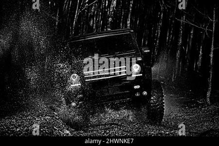 Schlamm und Wasser spritzen bei Offroad-Rennen. Geländewagen fährt auf den Berg. Jeep Abenteuer im Freien. Trekking im Geländewagen. Rally-Rennen. Stockfoto