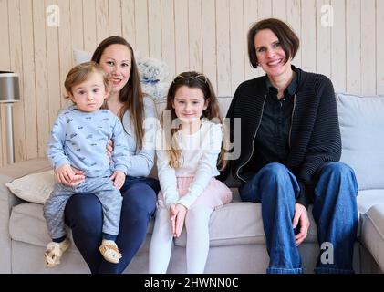 Berlin, Deutschland. 03. März 2022. Doula Denise Wilk (r sitzt neben einem Teil der Familie Landes: Maximilian 1 Jahre alt, Mutter Nina und Vicky, 8 Jahre alt. Vater und ältester Sohn können bei der Schießerei nicht anwesend sein. Neben Hebammen werden auch bei Geburten vermehrt Doulas benötigt. Wilk begleitete alle drei Geburten der Mutter. Quelle: Annette Riedl/dpa/Alamy Live News Stockfoto