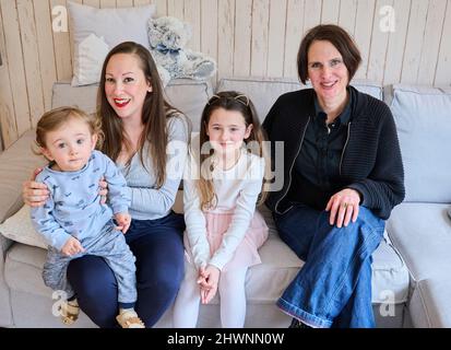 Berlin, Deutschland. 03. März 2022. Doula Denise Wilk (r) sitzt neben einem Teil der Familie Landes: Maximilian 1 Jahre alt, Mutter Nina und Vicky, 8 Jahre alt. Vater und ältester Sohn können bei der Schießerei nicht anwesend sein. Neben Hebammen werden auch bei Geburten vermehrt Doulas benötigt. Wilk begleitete alle drei Geburten der Mutter. Quelle: Annette Riedl/dpa/Alamy Live News Stockfoto