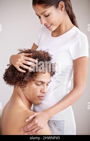Hes das einzige für mich. Ein junges ethnisches Paar hält sich sanft, wobei der Kopf des mannes auf dem Bauch seines Ehegatten ruht. Stockfoto