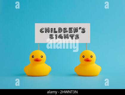 Gummienten tragen ein Schild mit der Botschaft Kinderrechte. Unterstützung, Schutz für Kinderbewusstsein. Stockfoto