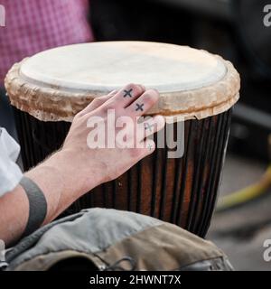 Männliche Hand, die ein Djembe Drum Bongo afrikanisches Musikinstrument spielt. Stockfoto