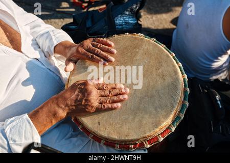 Hände eines afroamerikanischen Mannes, der Schlagzeug mit Djembe Drum Bongo spielt Stockfoto