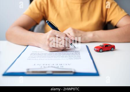 Frau Hand Unterzeichnung Vertrag Dokument. Kauf und Verkauf, Versicherung, Autovermietung und Vertragsvereinbarungen Konzepte Stockfoto