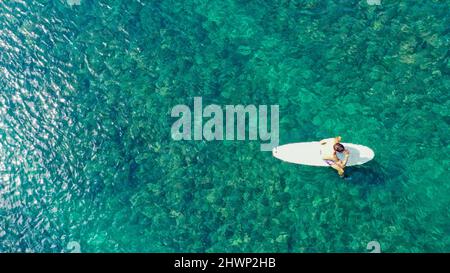 Surfer warten auf Wellen in einem klaren Wasser in der Nähe des malerischen Strandes, Blick auf die Drohne. Von oben nach unten. Kopieren Sie Platz für Ihren Text Stockfoto