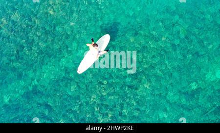 Surfer warten auf Wellen in einem klaren Wasser in der Nähe des malerischen Strandes, Blick auf die Drohne. Von oben nach unten. Kopieren Sie Platz für Ihren Text Stockfoto