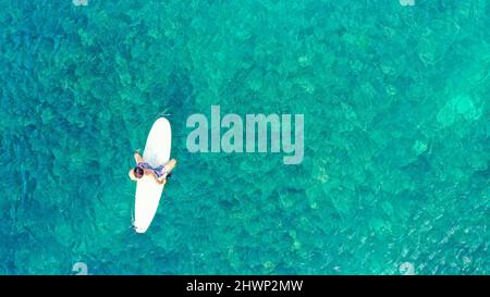 Surfer warten auf Wellen in einem klaren Wasser in der Nähe des malerischen Strandes, Blick auf die Drohne. Von oben nach unten. Kopieren Sie Platz für Ihren Text Stockfoto