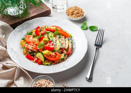 Eine Portion vegetarischen Salat mit Quinoa und Avocado auf grauem Hintergrund. Salat aus Tabbouleh. Gesunde Ernährung. Levantinischer vegetarischer Salat mit Bulgur, qui Stockfoto