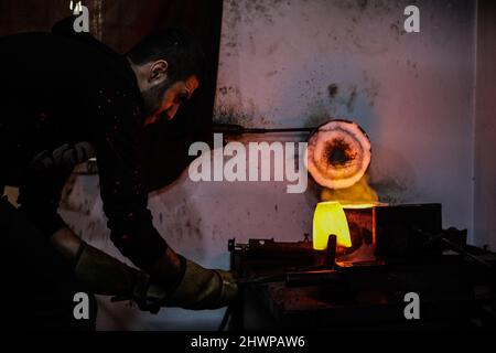 Gaziantep, Südostanatolien, Türkei. 4. März 2022. Gaziantep, Türkei. 04. März 2022. Nicht mehr verwendete Goldstücke werden in einer syrischen Gießerei in der türkischen Stadt Gaziantep geschmolzen. Die erste Stufe des Gold-Recyclings erfolgt durch das Schmelzen von Edelmetallstücken bei einer Temperatur von etwa 1060 Grad Celsius. Das Recycling von Gold ermöglicht eine nachhaltigere Produktion des Edelmetalls und macht es gleichzeitig erschwinglicher. (Foto: © Zakariya Yahya/IMAGESLIVE via ZUMA Press Wire) Stockfoto