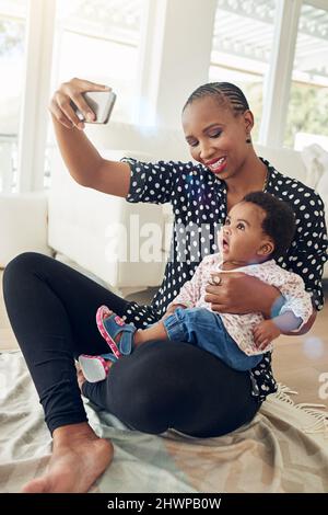 Ihr Lächeln ist zu süß. Aufnahme einer Mutter, die mit ihrem kleinen Mädchen ein Foto gemacht hat. Stockfoto