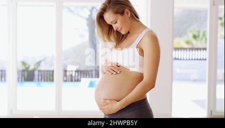 Von nun an bist du die Nummer eins in meinem Leben. Kurzer Schuss einer attraktiven jungen Schwangeren, die ihren Babybauch reibt. Stockfoto