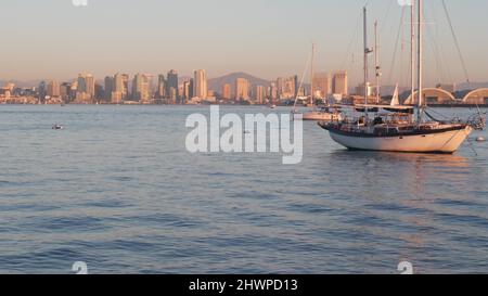 Jachten in Marina und Skyline der Innenstadt bei Sonnenuntergang, Stadtbild von San Diego, kalifornische Küste, USA. Hochhaus-Wolkenkratzer, Boot in der Bucht, Uferpromenade. Stadtarchitektur und Segelboot im Hafen. Stockfoto